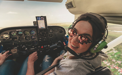 Young pilot with glasses smiling to the camera.