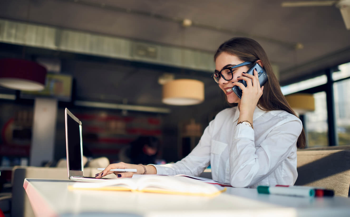Young pilot with glasses smiling to the camera.